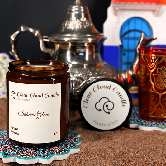 scented candle amber glass jar. Moroccan props. sand ground. candle name: sahara glow
